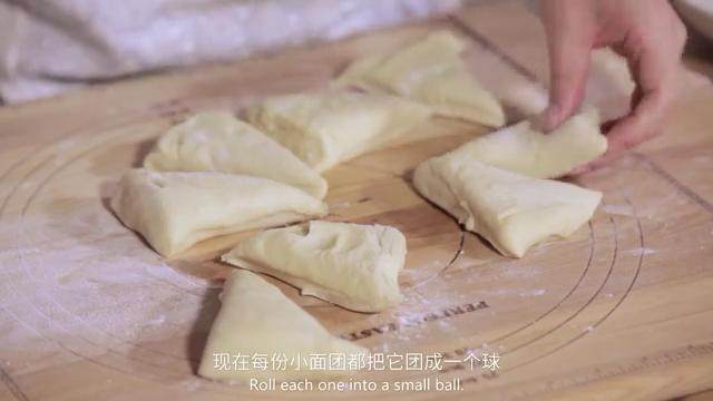 乳酪面包,在案板上撒点面粉,倒出面团按扁,切成8份