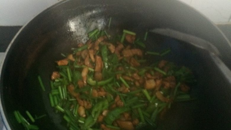 韭薹炒肉,韭薹颜色变深后加小半勺盐翻炒,再将刚刚炒好的猪肉倒去翻炒一分钟,加半勺盐翻炒一分钟