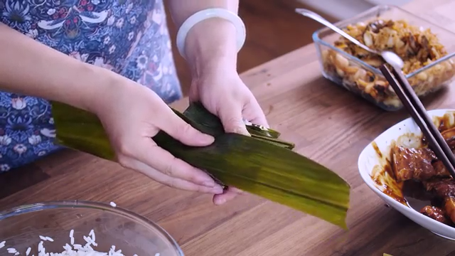 鲜肉粽子,两边往中间折，取另一片叶子，如图，毛面朝内，包好，两边往中间折，另一边亦如此