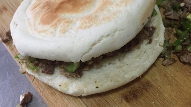 肉夹馍,把烙好的饼用刀切开,夹上剁碎的猪肉即可(也可根据自己的口味加入辣椒粉和孜然粉等调味)