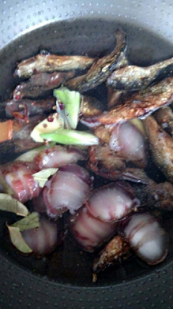 乡里土菜腊味合蒸,腊肉切块,把鱼和腊肉放凉水锅里焯水,锅里放入葱姜、香叶、八角、花椒,倒入一点白酒去腥。