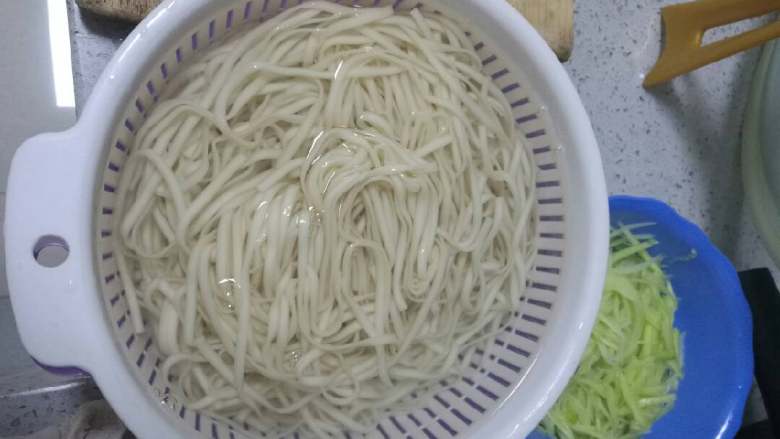 葱油拌面,取烧锅加水烧开后加入手打面,水再滚时激二次冷水,捞出面条放冷开水中过凉