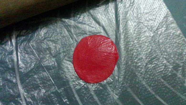 玫瑰巧克力#甜蜜美味#,取一小块巧克力搓成圆球,再隔着保鲜袋压平,四周要压得比较薄。