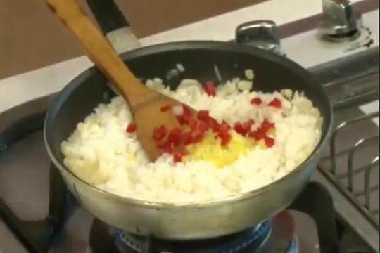焗海鮮燉飯,續作法1的鍋子加入飲用水、鹽、<a style='color:red;display:inline-block;' href='/shicai/ 720'>胡椒粉</a>煮勻後再加入白飯,煮至水份收乾後再加入黃甜椒丁、紅甜椒丁略為炒勻,再加入作法1的海鮮料一起拌炒。
