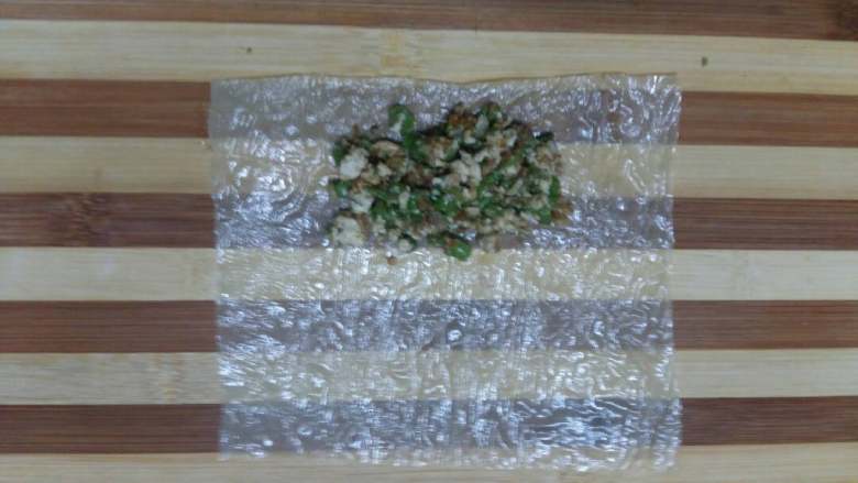 豆腐皮菜卷,取一张豆腐皮放在案板上摊平,菜馅放在豆腐皮的一边,两边留出空间。