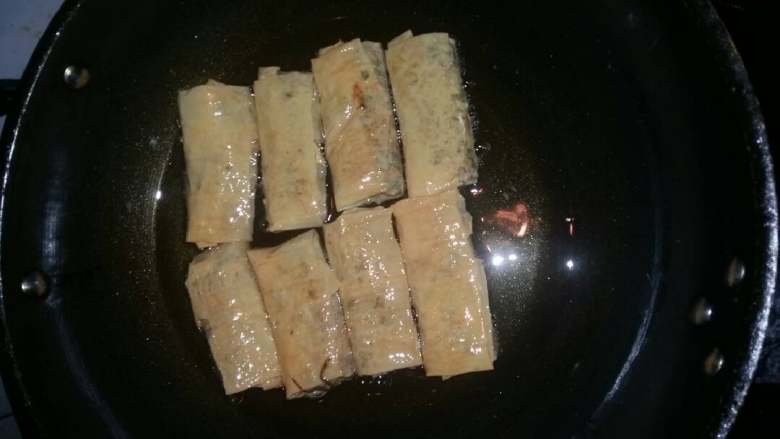 豆腐皮菜卷,锅烧热加油,下豆腐皮包开小火慢慢煎至两面金黄即可出锅。