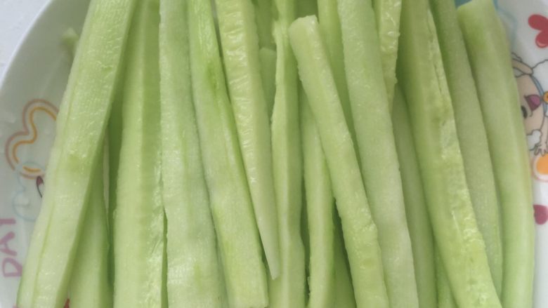 紫菜包饭,将洗净切段的黄瓜切成长细条,装盘待用