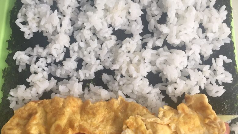 紫菜包饭,取<a style='color:red;display:inline-block;' href='/shicai/ 279'>海苔</a>一片,将所有材料平铺在上面
