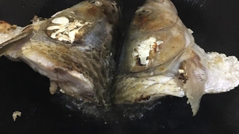 鱼头豆腐汤,锅里放油,将鱼头两面煎至金黄