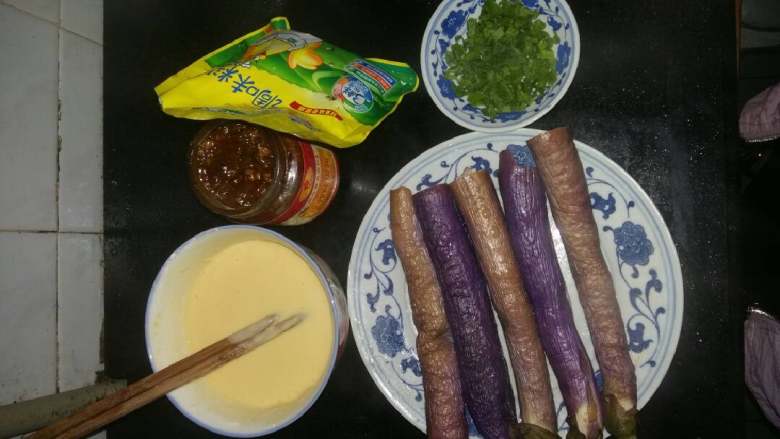 外脆里嫩茄子饼,先把面糊打好,面粉容器里倒入鸡蛋,淀粉加入盐水,一直打到面粉没有小颗粒为止。