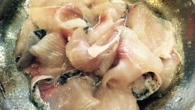 麻辣风味花莲鱼,在事先准备好的鱼肉片(把水倒掉)中放入盐、生粉、蛋清、黄酒,用手轻搅拌,腌制10分钟。