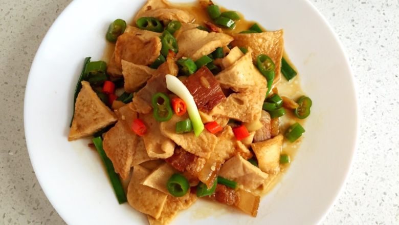 小炒千叶豆腐,热锅冷油，放腊肉入锅煎一下，姜蒜也入锅炒香，闻到香味后放入豆腐一起炒，随后放适量料酒，生抽，翻炒一下，放入青红辣椒和葱段，炒熟后加少许蚝油，翻炒均匀即可出锅，美味好吃的小炒<a style='color:red;display:inline-block;' href='/shicai/ 4688'>千叶豆腐</a>就做好了。