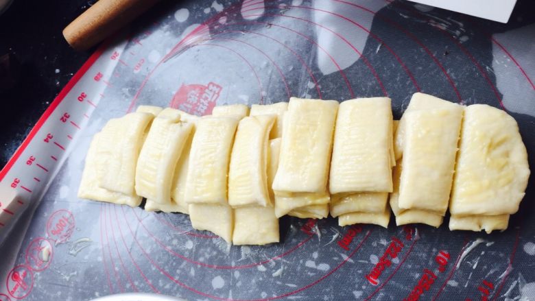 香浓炼乳面包.,面条一条条叠起来,中间切开,一共切成8块,模具抹上少许黄油.放入面团