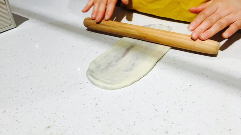 抹茶红豆吐司,用擀面杖把包了馅料的面团擀成一个长的烧饼状 (从中间往上下两头擀 不要太用力噢 小心馅料会破洞而出)