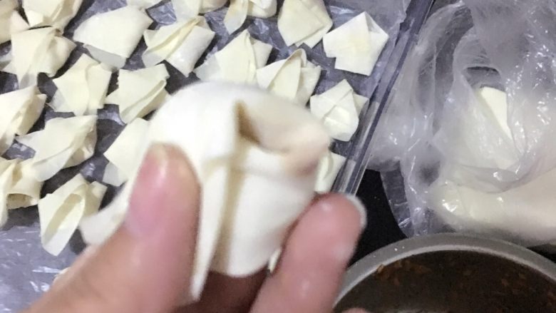 包面(馄饨),最后把两个角一绕粘在一起就完全了