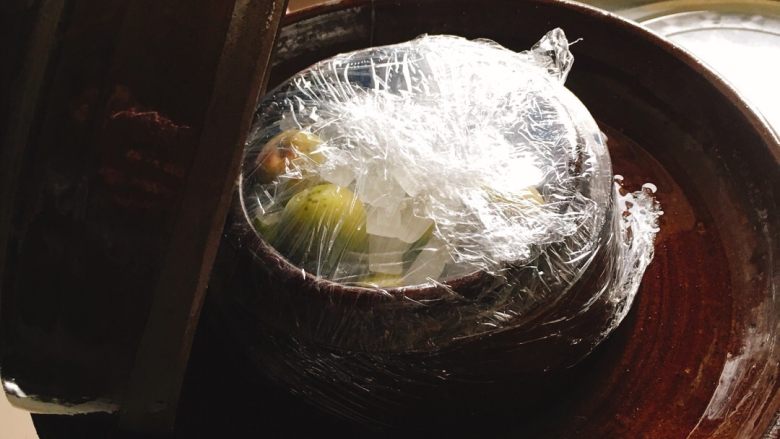 自制青梅汁,用保鲜膜把坛口封住。