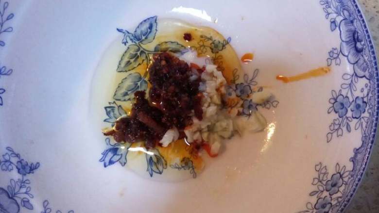 西红柿鸡蛋刀削面,在碗里放入葱花蒜末,少许的凉拌酱油和<a style='color:red;display:inline-block;' href='/shicai/ 46917'>老干妈辣椒酱</a>