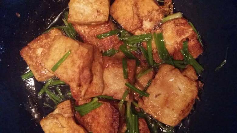 烫豆腐,烫成里面金黄，加美味鲜少许水慢火煎一下，撒上葱鸡精炒匀出锅。