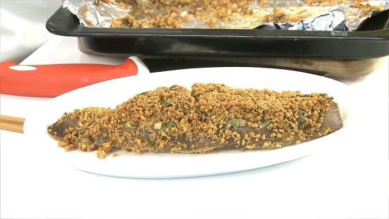 用烤箱做豆酥鱈魚,烤熟後取出盛盤,再擺上蔥絲和紅辣椒絲裝飾即可。