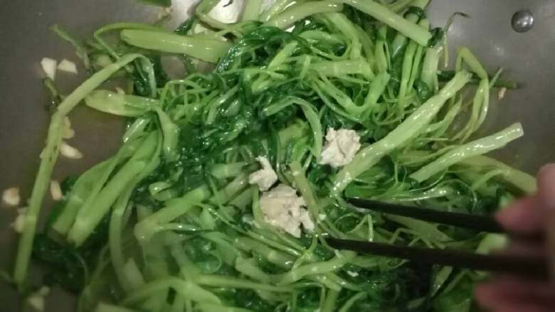 椒丝腐乳炒通菜,很快通菜就变得软软绿绿的,就换上用筷子来炒,这时候加入<a style='color:red;display:inline-block;' href='/shicai/ 734'>腐乳</a>再加少许盐拿筷子来拌匀。