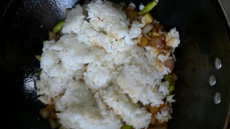 闷饭,七成熟时放入剩饭,加入高汤没有可以用水代替,注意控制加入的水或者高汤的量。