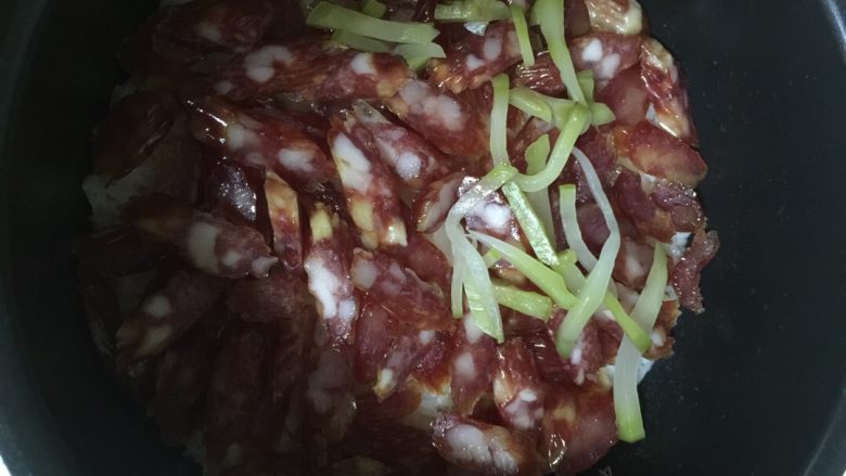 腊味饭,煮好饭后先放入腊肠,再放榨菜丝。