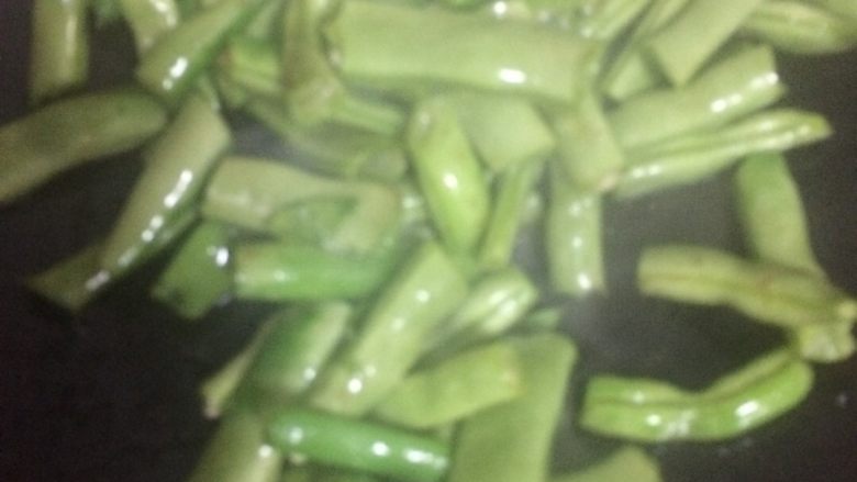 肉焖面,锅中放适量油,接着放入豆角,翻炒,直到豆角变色即可