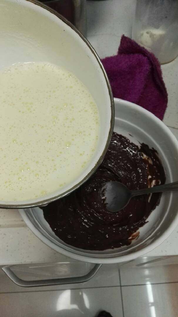 巧克力慕斯蛋糕,再将有蛋黄的牛奶慢慢倒入巧克力中,同样一开始要边倒入边顺时针打发,这里需要慢慢搅拌,不然巧克力容易结块,最后等巧克力全融化于牛奶液中时,再将牛奶全部倒入,充分打发