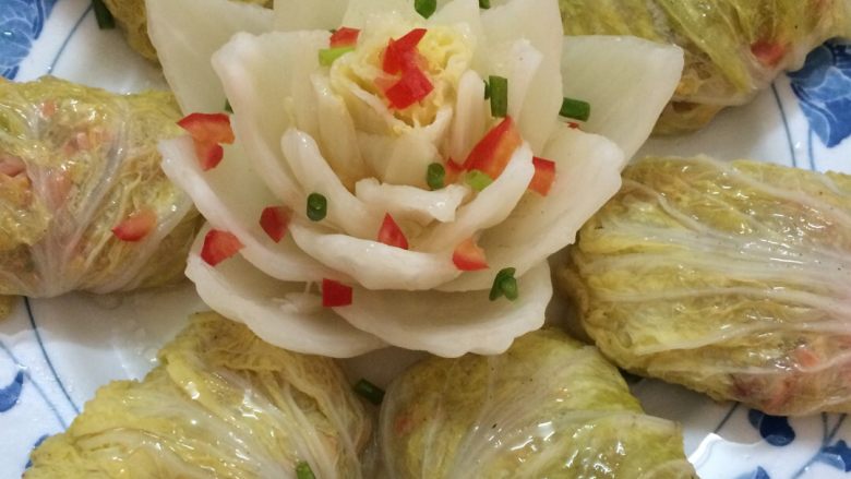 莲花白菜包,装盘,蒸20分钟,出锅时在白莲上加上葱花和西红柿丁,最后烧开油淋上菜包。