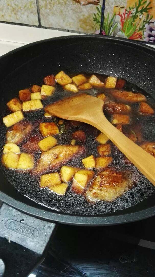 苹果鸡翅,加入热水至默过鸡翅,用大火烧开,然后调中火煮一刻钟左右,再开大火收汁