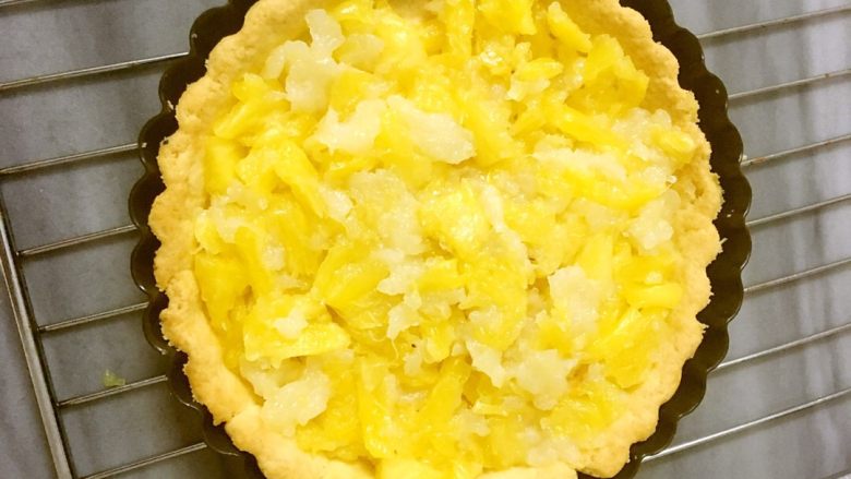 菠萝批(6寸版),铺上烘焙纸,放上小石头或豆子压住派皮进烤箱180度中层,烤15分钟,表皮上色即可,取出,把菠萝现填入