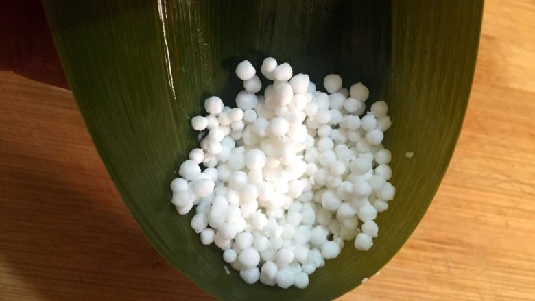柠味水晶粽,煮透的粽叶过冷水,取两个粽叶头尾相对折成漏斗状
加入少许西米