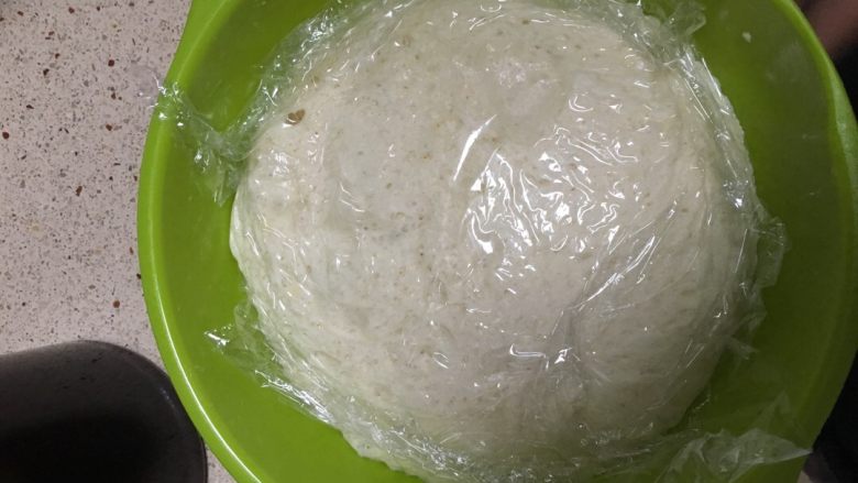 汤种酥皮菠萝包,主面团二次发酵:一次发酵至如图后(两三倍体积)后。再次揉搓至面团缩小。烤箱内更换热水后再次盖上保鲜膜再次发酵半小时。