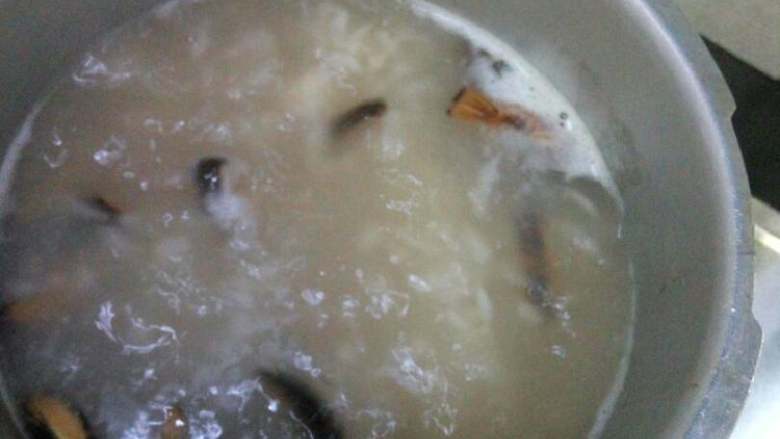 海鲜粥,将炒好的鱿鱼香菇加入粥里继续煮10分钟,在加入虾