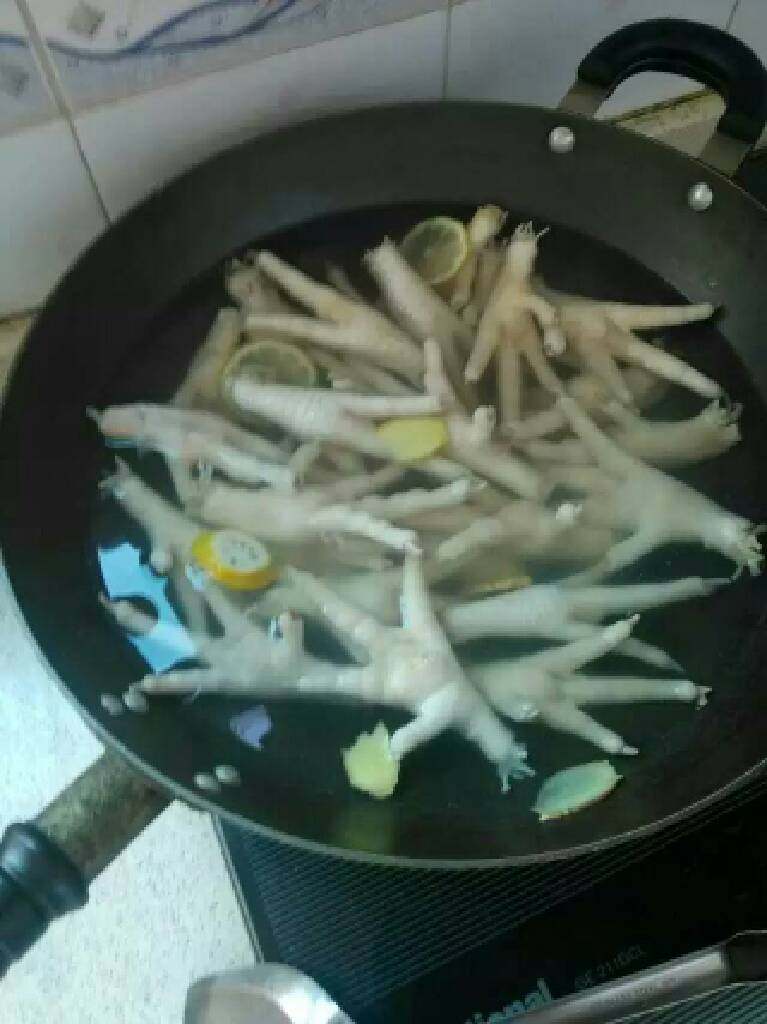 电饭锅盐焗鸡脚,放入洗干净的鸡脚，煮开两分钟，关火泡十分钟