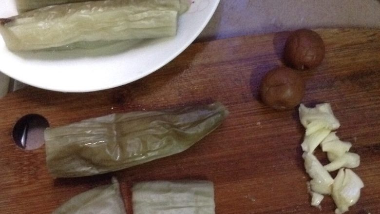 咸梅白茄子,把茄子捞起,凉一点再切成两半。