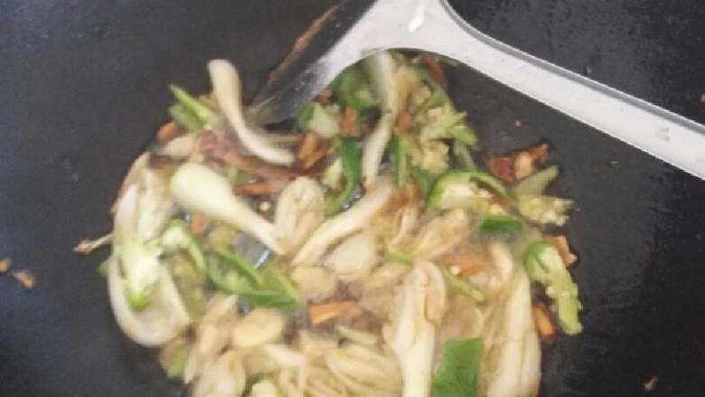 红烧鲫鱼,把鱼煎好后盛在盘子里,把荞头和辣椒倒入锅中翻炒