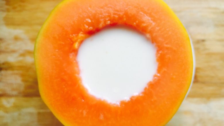 木瓜牛奶冻,把木瓜放到碗中，将牛奶倒入木瓜中