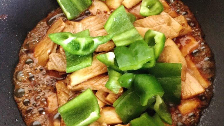 肉片杏鲍菇,加入青椒,翻拌二三分钟。