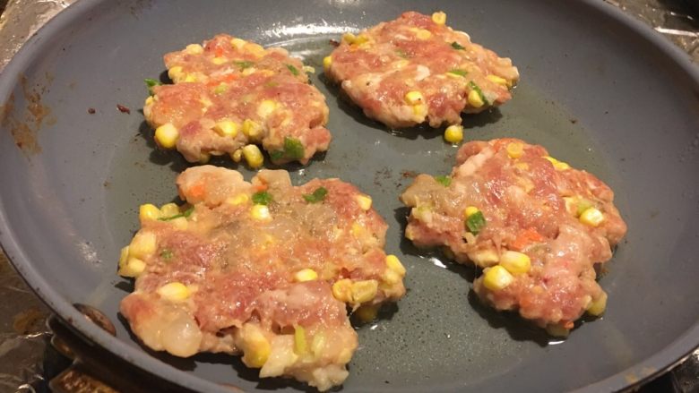 香煎肉饼,锅里放点油,烧热把球放进去,并压扁。