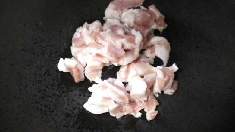 五花肉炒花菜,锅里放入五花肉,小火煸炒。