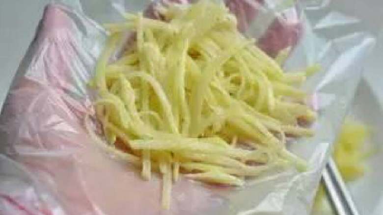 三文鱼薯饼,手上套保鲜袋，取适量土豆丝在手中整成小的圆饼形。