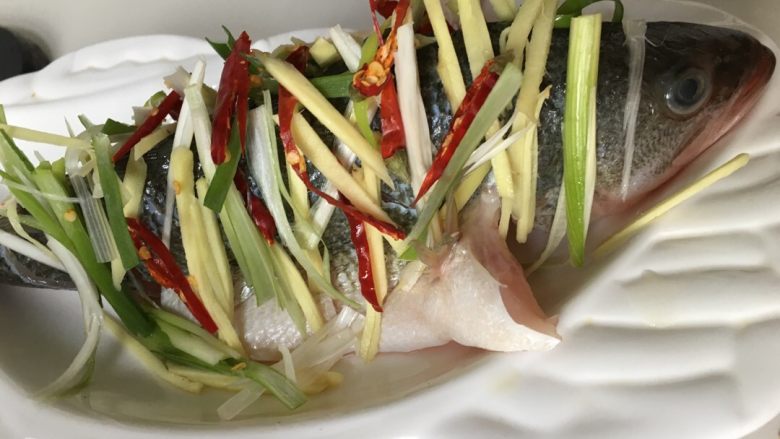 清蒸鲈鱼。,将<a style='color:red;display:inline-block;' href='/shicai/ 371'>鲈鱼</a>尾部稍微切开,使鱼保持立在盘中的造型,觉得麻烦的亲可以直接把鱼平放哈,然后在鱼的背部放上葱姜蒜辣椒等佐料,水开后放入蒸锅。对了,鱼要提前用盐和蚝油料酒腌一下。