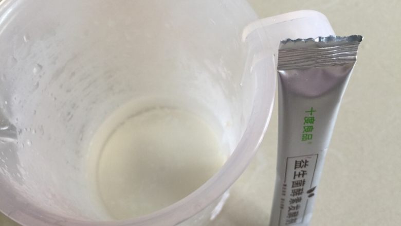 水果酵素,激活菌粉,在量杯中加入100ml的温开水(40度左右),倒入菌粉搅拌溶解待用