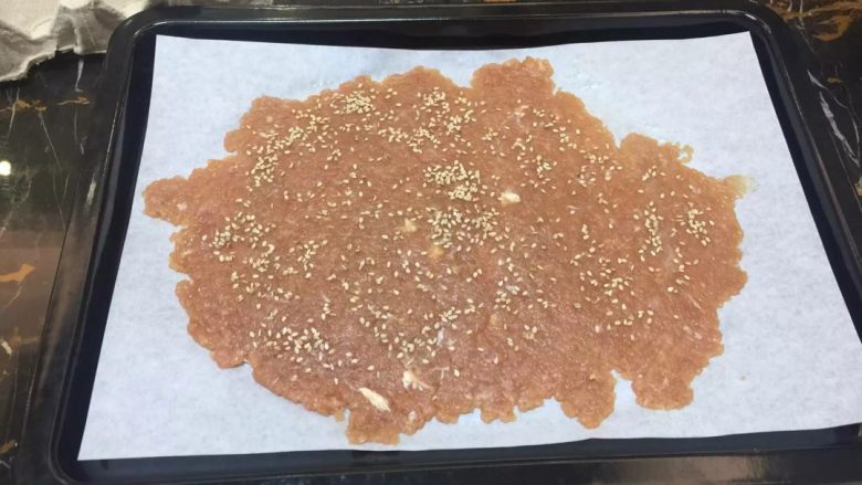 猪肉铺,锡纸按照烤盘的尺寸剪好，放在平整的地方，把肉放在锡纸上，再在肉的上面盖上一层保鲜膜，用擀面杖把肉碾成2毫米厚，不要过薄也不要过厚，我这里用的是第一次做的图，用了油纸，发现不太好，改成用锡纸，碾好后撕掉保鲜膜，把锡纸和肉挪到烤盘上