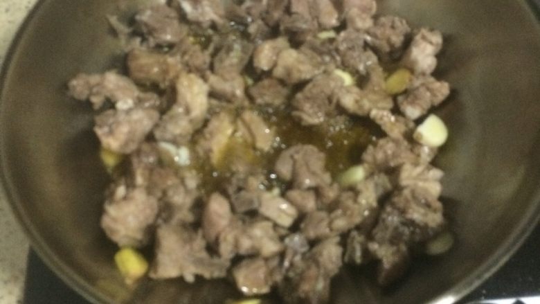 私房排骨,土豆和排骨是绝配哦,烧排骨要多倒一些油,然后把冷却的排骨倒入锅里,加入姜蒜,开小火爆一下。
