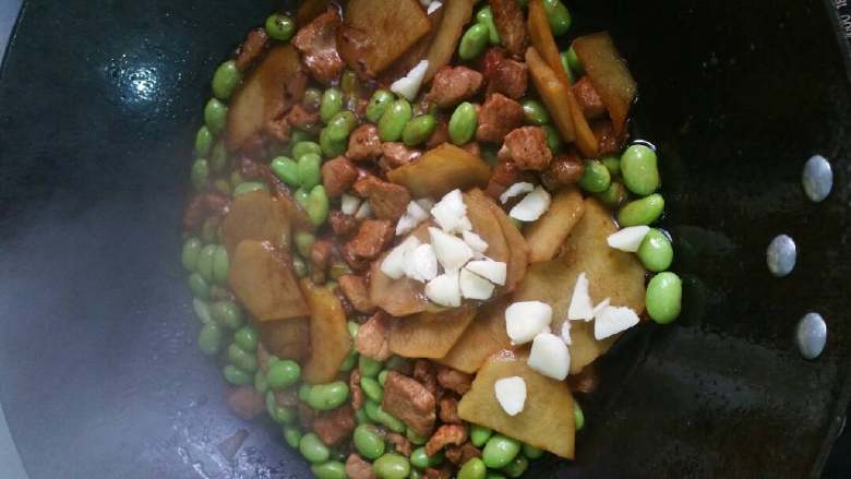 土豆毛豆肉,放进蒜头，向锅中四周倒些清水煮。等水煮干就好了