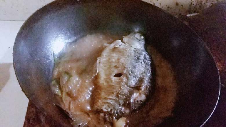 红烧鲫鱼,趁着香味,倒入适量水,水要稍微盖过鱼。盖上盖子,大火1分钟,然后一直小火。