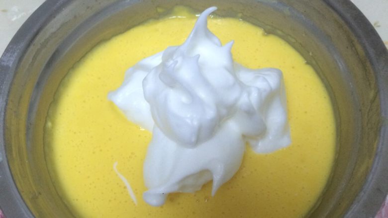 微波棉花牛奶蛋糕,将三分一份量蛋清糊放入蛋黄糊，用炒菜方法慢慢搅拌均匀，一点钟方向插入七点钟方向提起慢慢搅拌，一边搅拌一边转动盆使蛋糊搅拌均匀