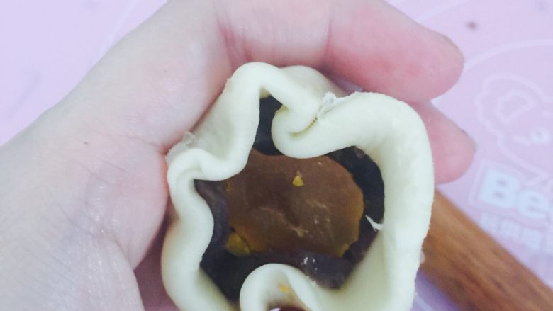 豆沙蛋黄一口酥,松弛好的面皮擀成圆饼后包入适量豆沙和切好的1/3块蛋黄
